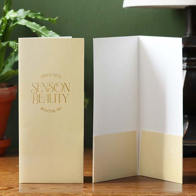 Ivory gloss pocket folder with gold foil logo imprint on the front cover